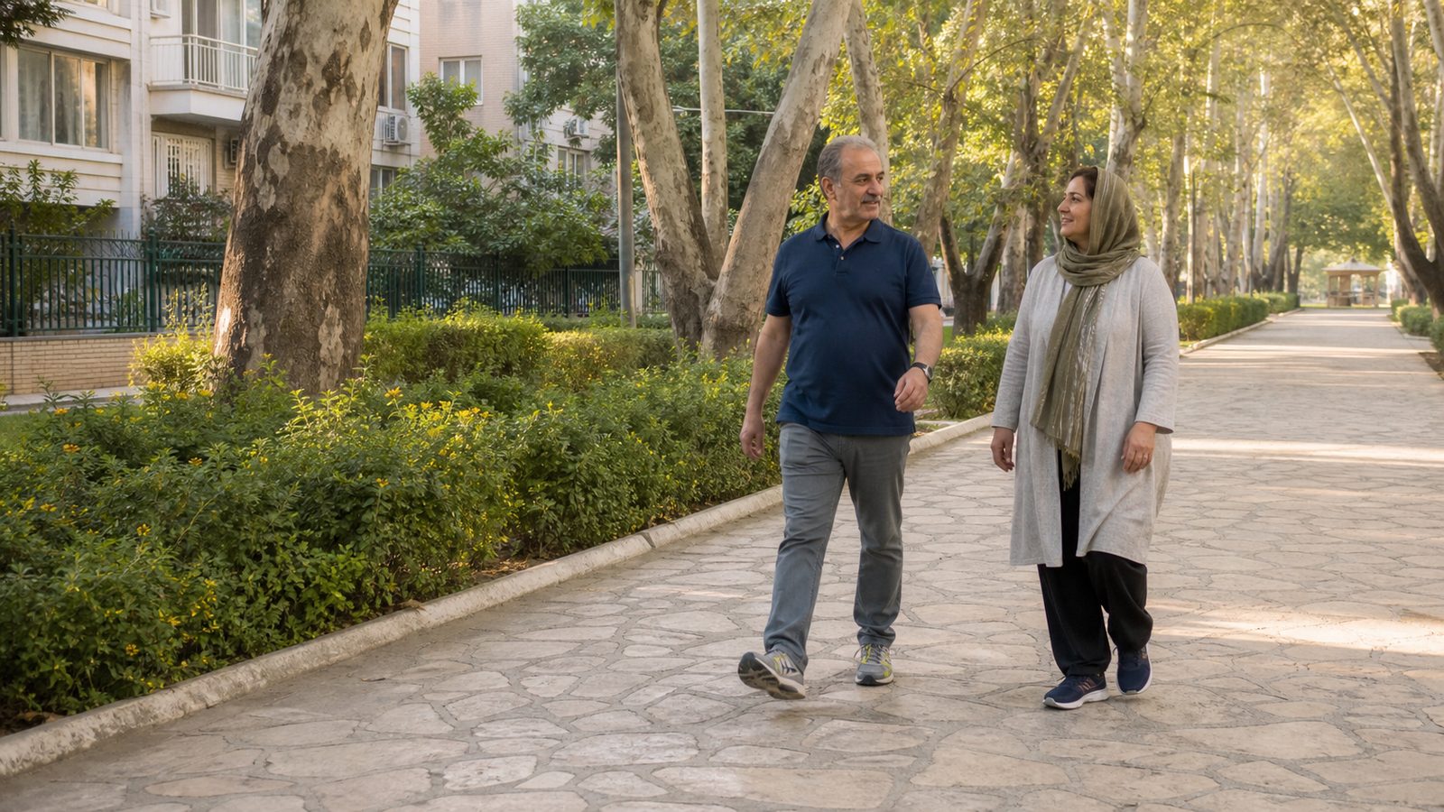 دو بزرگسال ایرانی در مسیر درخت‌کاری‌شدهٔ پارک محله برای پیاده‌روی روزانه