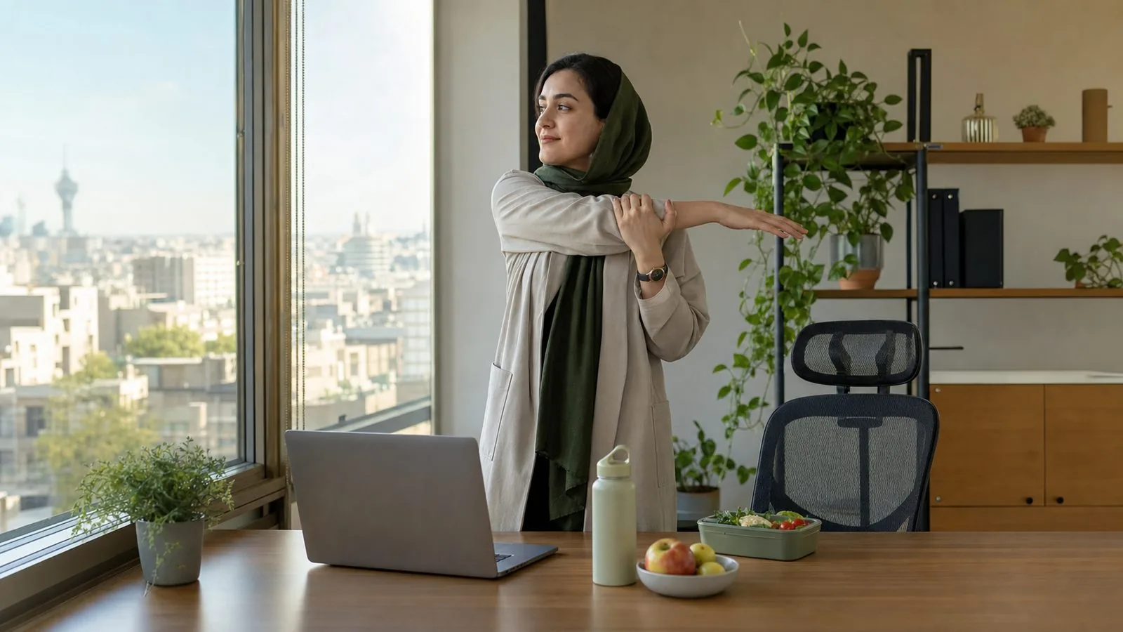 کارمند ایرانی در حال کشش کوتاه کنار میز کار برای حفظ عادت‌های سالم
